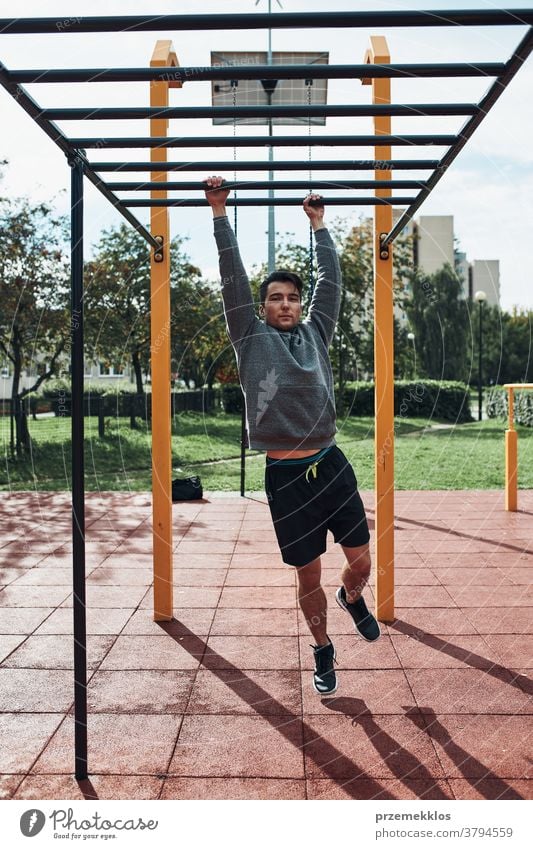 Junger Bodybuilder, der während seines Trainings in einem modernen Gymnastikpark auf Affenstangen trainiert calisthenics Pflege Kaukasier Gesundheit Lifestyle