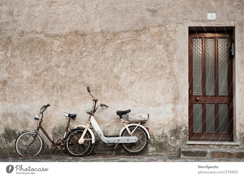 Gemeinsam rosten Italien Dorf Kleinstadt Altstadt Haus Gebäude Mauer Wand Fassade Tür Fahrzeug Motorrad Fahrrad Kleinmotorrad alt ästhetisch kaputt retro