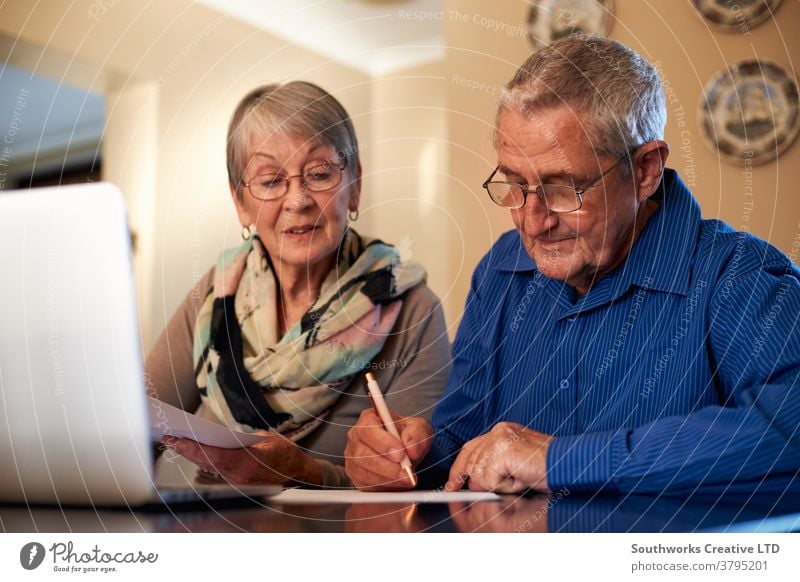 Älteres Ehepaar zu Hause überprüft persönliche Finanzen am Laptop Paar Senior Senioren in den Ruhestand getreten Technik & Technologie Computer online verbunden