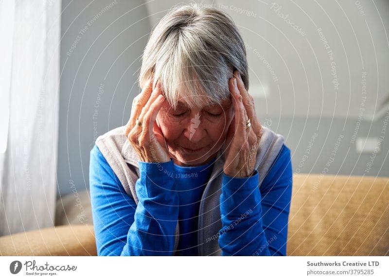 Ältere Frau leidet unter Stress oder Kopfschmerzen zu Hause und hält den Kopf unter Schmerzen Senior Senioren Migräne Gesundheit Beteiligung gestresst