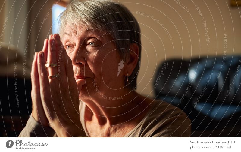 Nahaufnahme einer älteren Frau, die zu Hause gemeinsam betet oder mit den Händen meditiert Senior betend Gebet religiös Glaube Senioren Religion meditierend