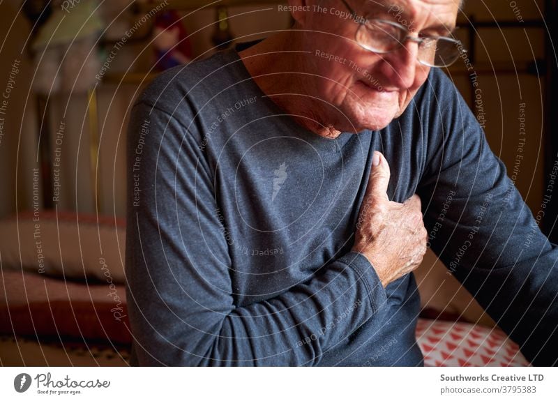 Älterer Mann mit Gesundheitsproblemen zu Hause klammert sich schmerzhaft an die Brust Senior Beteiligung Truhe Schmerz Herzinfarkt Senioren umklammert krank