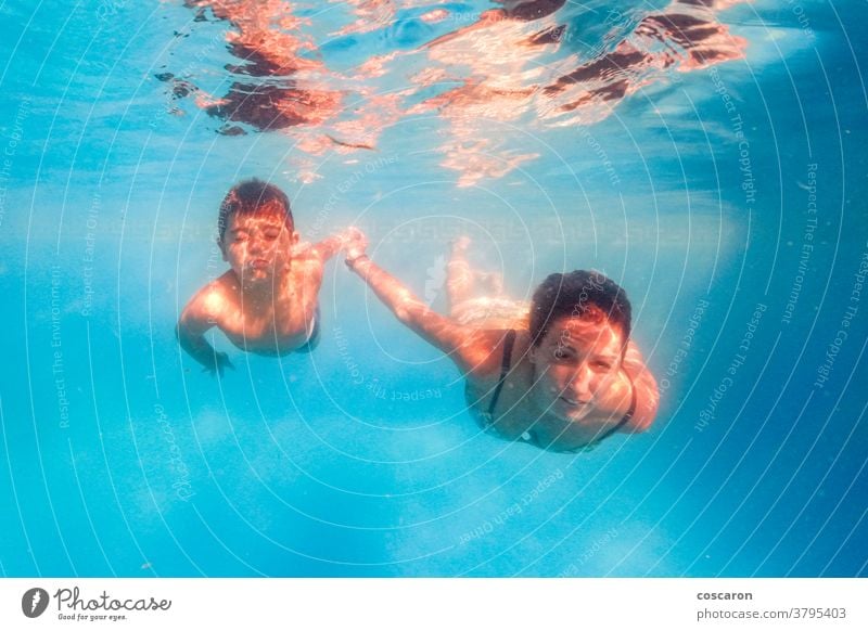 Mutter und Sohn tauchen in einem Schwimmbad Aktion aktiv Aktivität aqua Baby schön blau Junge Kind Kinder Tochter Sinkflug Taucher Tauchen Emotion genießen
