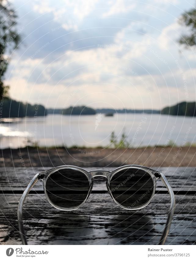 Wunderschöner See hinter einer Sonnenbrille gesehen Accessoire Hintergrund Textfreiraum Brille durch eine Sonnenbrille schauen persönliche Perspektive