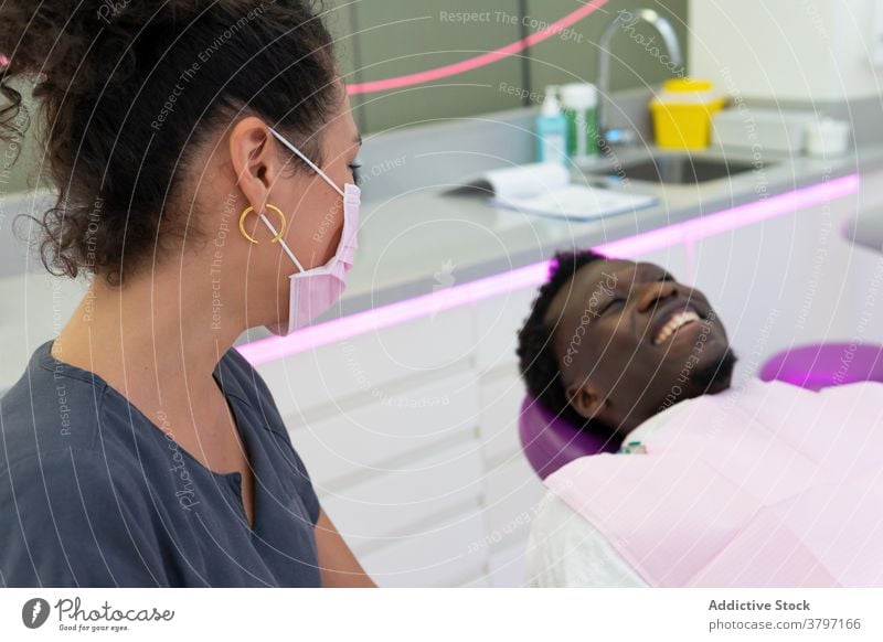 Lächelnde schwarze Zahnarzt und Patient im medizinischen Raum Arzt geduldig Leckerbissen Verfahren dental Zahnmedizin Stomatologie ethnisch Afroamerikaner