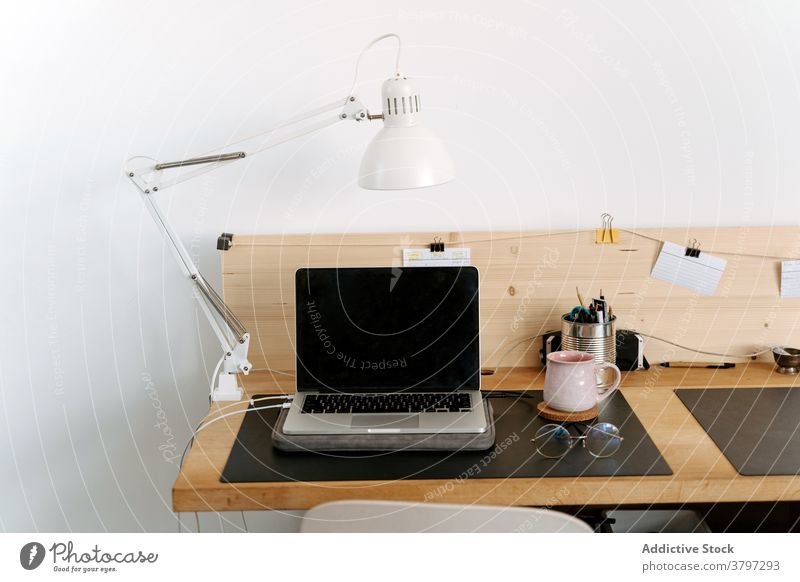 Zeitgenössischer Laptop und Brille auf Holztisch Arbeitsplatz Apparatur Büro organisieren klug modern Netbook tragbar Arbeitsbereich schwarzer Bildschirm Gerät