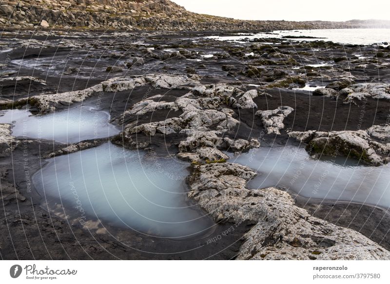 Kleine milchige Pfützen zwischen auf dem Weg neben dem Wasserfall Felsen Stein grau wandern Wanderung unwegsam sand einsam Urlaub Ferien Island