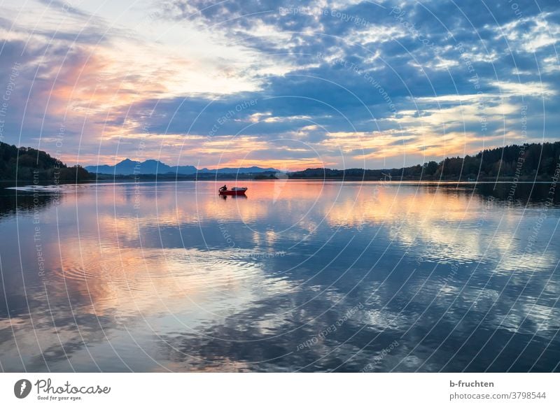 einzelnes Fischerboot am See in der Abenddämmerung Sonnenuntergang Dämmerung Silhouette Landschaft Wolken Himmel Natur Außenaufnahme Horizont Abendstimmung