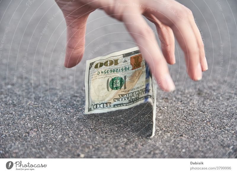 Heben Sie eine Hundert-Dollar-Banknote vom Boden auf. Konzept des gefundenen Geldes verirrt finden Straße im Freien Bürgersteig Person Tropfen Bargeld Rechnung