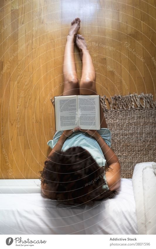 Anonyme Frau liest Buch im Schlafzimmer lesen heimwärts sich[Akk] entspannen Pyjama Wochenende ruhen gemütlich Literatur Stock Bett interessant Etage sitzen