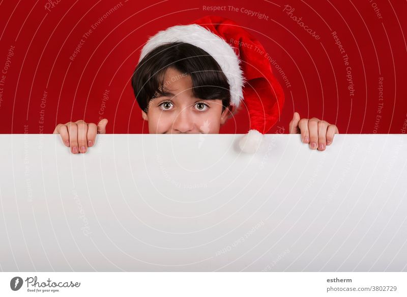 Fröhliche Weihnachten,lächelndes Kind Weihnachtsmann Mütze haltendes leeres Brett x-mas Feier Weihnachtsmütze Inserat Spaß leere Tafel Lächeln Fröhlichkeit