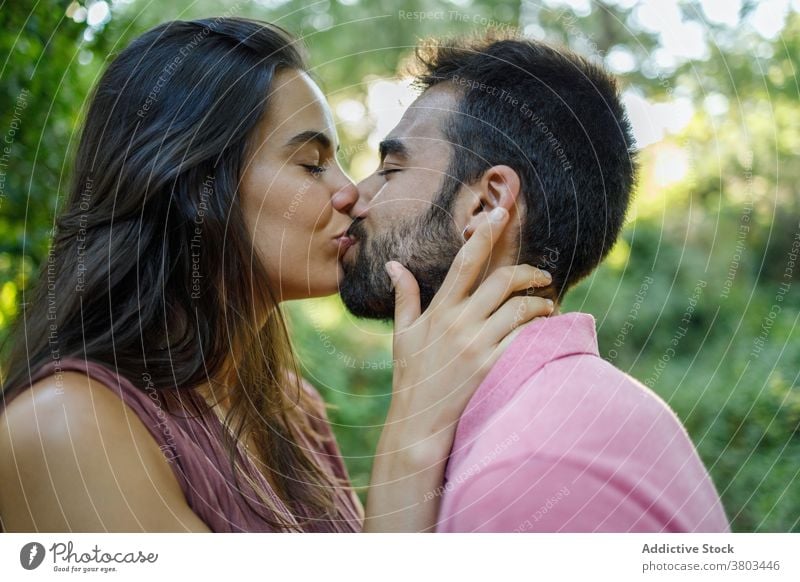 Liebendes ethnisches Paar, das sich im sonnigen Park küsst Kuss sinnlich Augen geschlossen verliebt Partnerschaft Leidenschaft Liebhaber amourös Versuchung