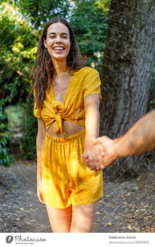 Glückliche ethnische Frau verbringt Zeit im Park mit anonymen Freund während der Sommerferien Händchenhalten heiter Feiertag Paar Partnerschaft Zusammensein