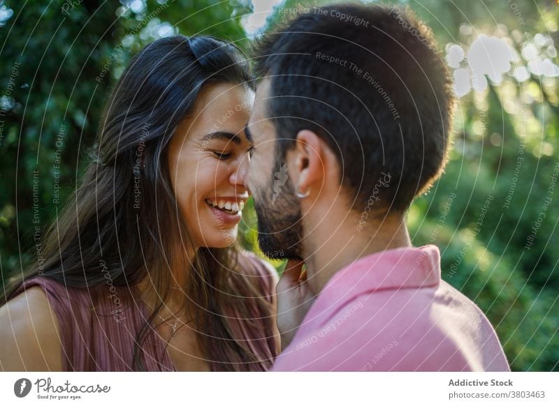Liebendes ethnisches Paar im sonnigen Park verliebt sinnlich Augen geschlossen Partnerschaft Leidenschaft Liebhaber amourös Versuchung Zuneigung Angebot