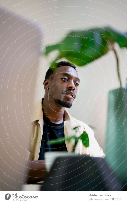 Schwarzer Freiberufler, der von zu Hause aus arbeitet Mann Arbeit Laptop abgelegen freiberuflich ernst Fokus selbständig Job Projekt männlich Afroamerikaner