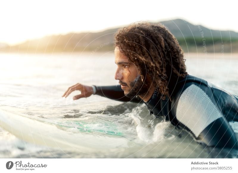 Konzentrierter Surfer schaut auf kommende Welle Mann winken MEER Meer Wassersport Sommer Fokus Freizeit Surfbrett männlich ernst besinnlich krause Haare