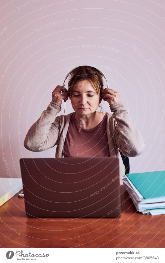 Frau, die während eines Videochat-Telefongesprächs mit einem Laptop von zu Hause aus arbeitet und dabei ihre Arbeit aus der Ferne erledigt Ordner Anruf