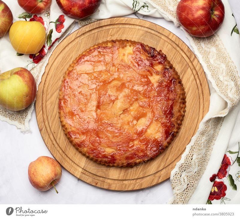 gebackener runder Apfelkuchen auf Holzbrettern und frische Äpfel Pasteten oben Kuchen Gebäck Dessert selbstgemacht Lebensmittel Amerikaner lecker Erntedankfest