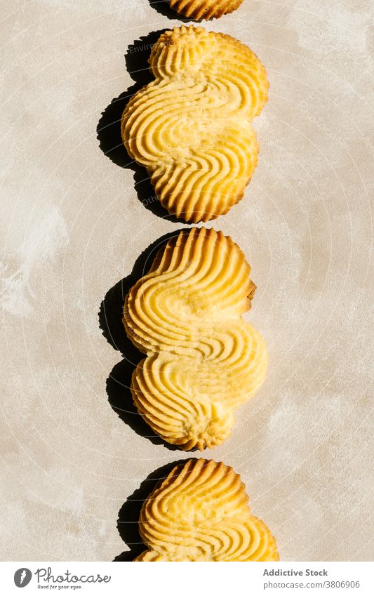 Helle goldene gebackene Kekse mit Ornament auf dem Tisch Biskuit Leckerbissen Gebäck lecker süß kreativ Design Hintergrund dekorativ farbenfroh natürlich