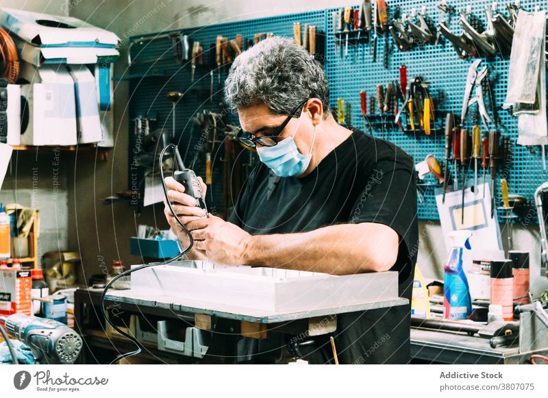 Professioneller Handwerker beim Maskenlöten von Details in der Werkstatt Mann Kunsthandwerker Fokus Arbeit Arbeitsplatz Beruf Kleinunternehmen Heimwerker