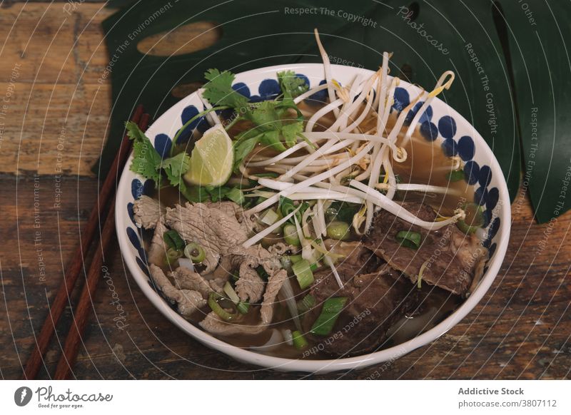 Schüssel mit leckerer vietnamesischer Suppe mit Rindfleisch auf dem Tisch pho Vietnamesisches Essen Bohne sprießen Schalen & Schüsseln Tradition dienen frisch