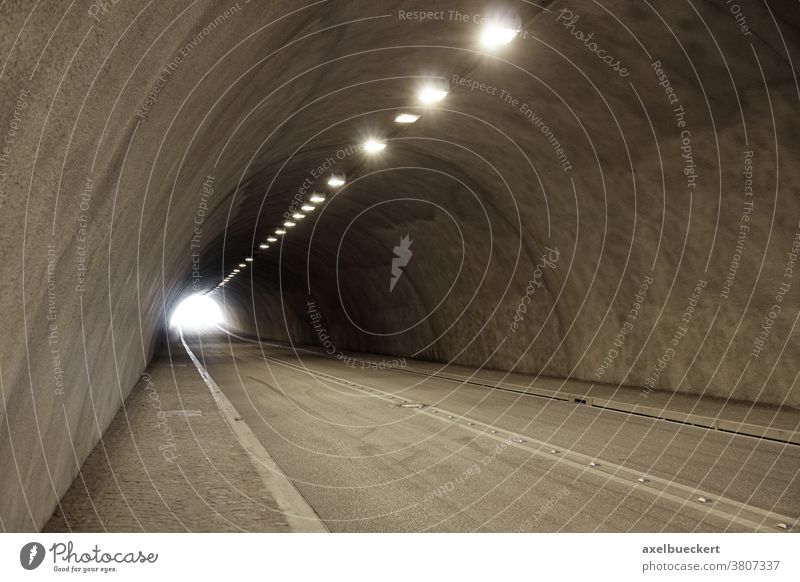 leerer beleuchteter Autotunnel Tunnel Straße Straßenverkehr Licht am Ende des Tunnels Unterführung Verkehr Transport reisen Zement Textfreiraum Hintergrund hell