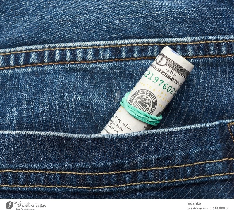 Hundert-Dollar-Scheine aus Papier zusammengerollt und mit grünem Gummiband festgezogen Gewebe Finanzen finanziell Franklin hundert Investition Jeanshose Geld