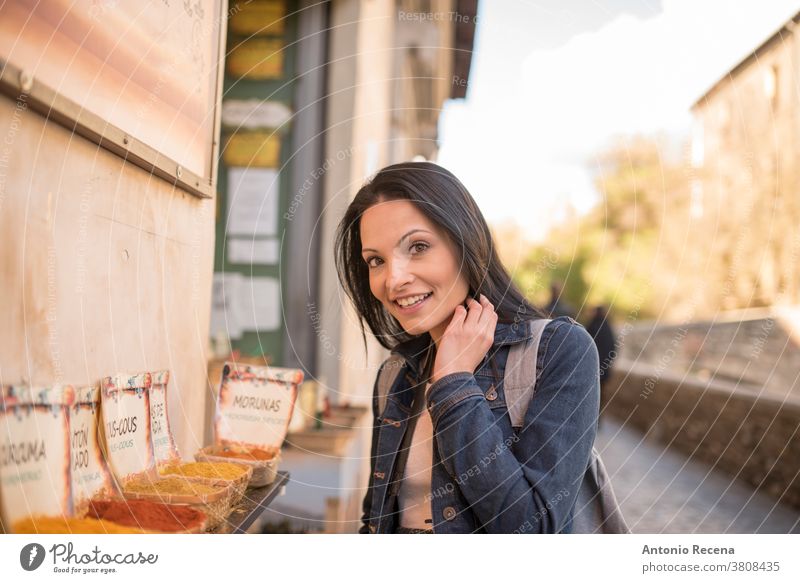 Hübsche, duftende Frau, Gewürze; spanischer Text: "Kurkuma, Cous Cous Cous, Gewürz, Paprika" Sie macht Tourismus in Granada, Spanien und besucht Orte in der Nähe von "La Alhambra".