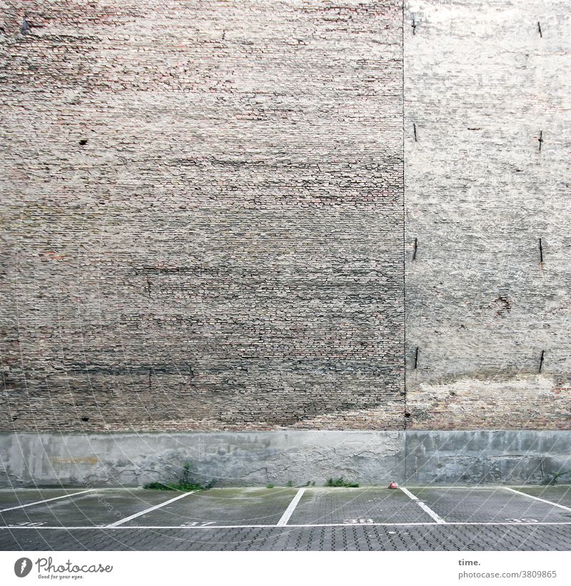 Hausordnung mauer wand parkplatz stein nummerierung hinterhof leer unbenutzt einsam Stellplatz verkehr backstein backsteinmauer streifen zuordnung zuweisung