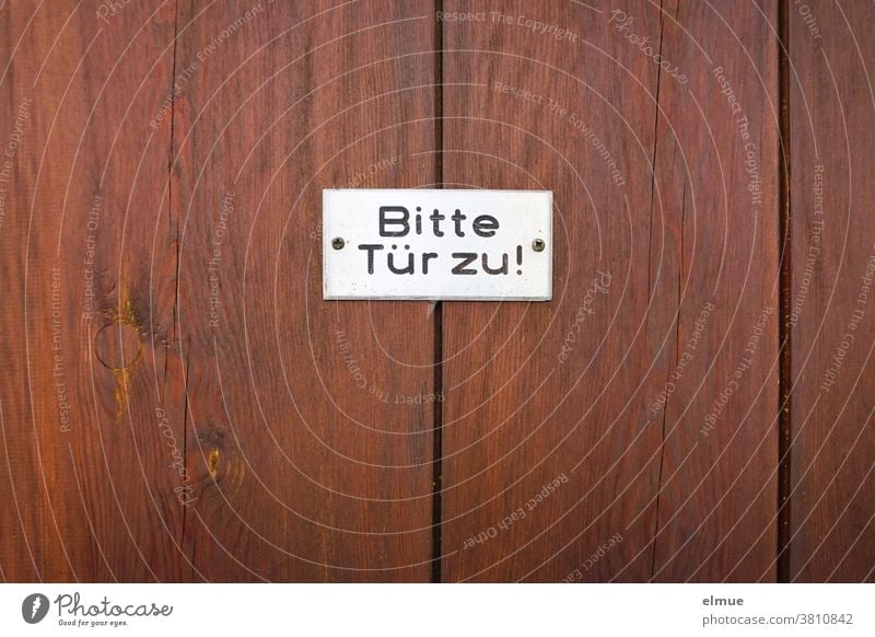 "Bitte Tür zu" steht in schwarzer Schrift auf einem weißen Schild an einer rotbraunen Holztür Bitte Tür zu! Aufforderung geschlossen Hinweisschild Eingangstür