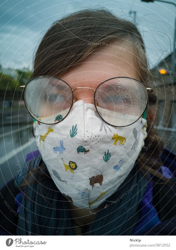 junge Frau trägt eine Maske und eine beschlagene Brille im Herbst / Winter (Corona / Covid-19) Junge Frau Maskenpflicht Hygienevorschrift COVID-19 Beschlagen