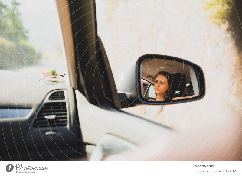 Blick einer jungen Frau auf den Rückspiegel eines Autos fahren Rückansicht PKW Verkehr Ausflug Autoreise Straße Porträt Fahrer Spiegel Gesicht schön reisen