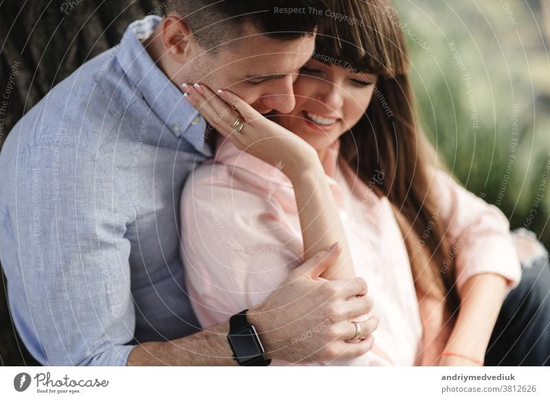 Bild Nahaufnahme eines glücklichen, fröhlichen Paares in Sommerkleidung, das beim Spaziergang im Park lächelt und sich umarmt. Sie küssen und umarmen sich. selektiver Fokus