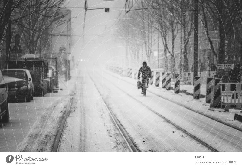 eine verschneite Straße mit einem Radfahrer in Berlin Prenzlauer Berg kastanienallee Winter radfahrer Außenaufnahme Stadtzentrum Tag Altstadt Gleise Baustelle