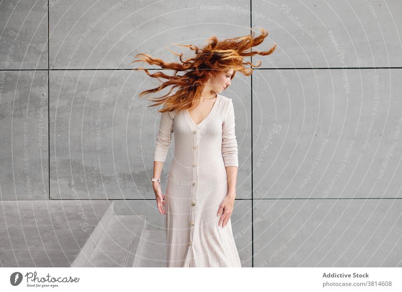 Ginger Frau mit fliegenden Haaren stehen in der Nähe der Wand Rotschopf Ingwer Behaarung Wind urban Stil lange Haare modern fliegendes Haar rote Haare trendy