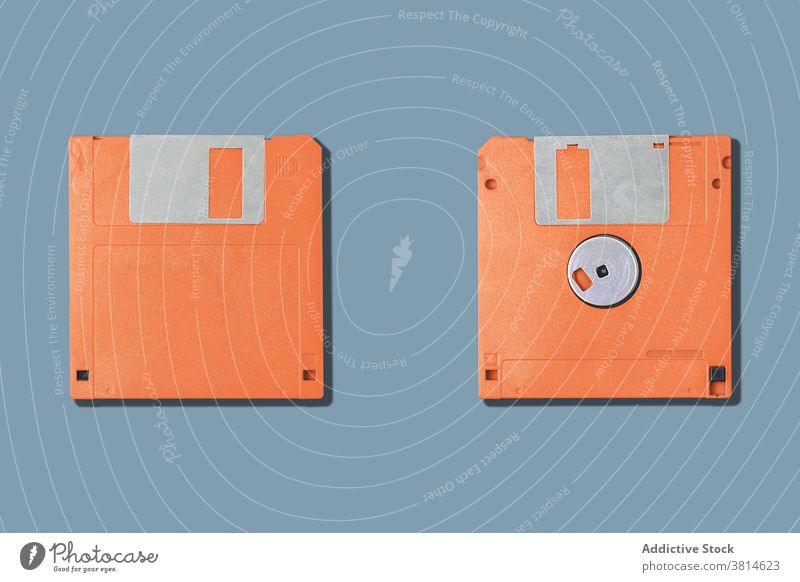 Computer-Disketten auf grauem Hintergrund Floppy zwei Lamelle alt pc altmodisch Information Daten veraltet orange Gerät Werkzeug altehrwürdig retro Accessoire
