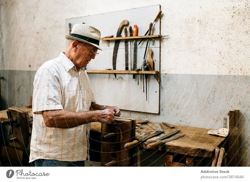 Älterer männlicher Holzarbeiter bei der Arbeit in der Garage Grinden Schreinerei Werkstatt Mann Zimmerer Tischlerin Holzarbeiten Pferch Ventilator handgefertigt