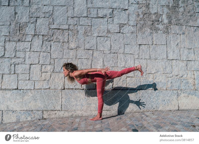 Schlanke Frau stehend in Warrior-Yoga-Pose Krieger Variation Gleichgewicht Asana beweglich üben positionieren schlank Wellness Harmonie Wohlbefinden Aktivität