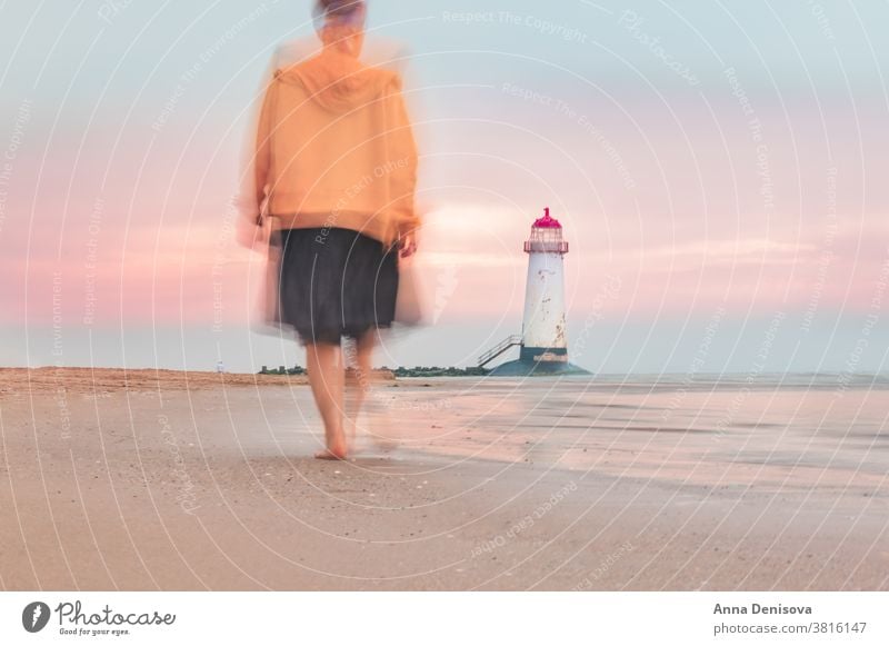 Verschwommene Bewegung der sich auf den Leuchtturm zu bewegenden Frau verschwommen Ayr-Spitze talacre Ufer Wales MEER laufen Person reisen Unschärfe Dame Strand