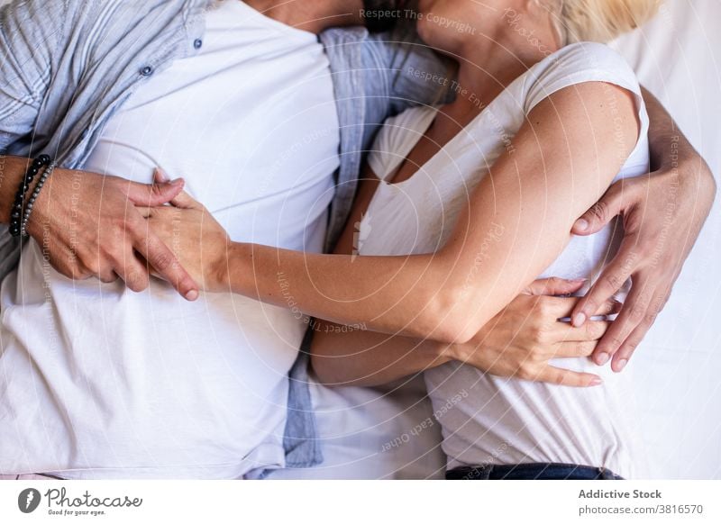 Anonymes zärtliches Paar, das sich auf dem Bett zu Hause umarmt Umarmung Lügen kuscheln Angebot Partnerschaft Liebe Zusammensein berühren Zuneigung Glück ruhen