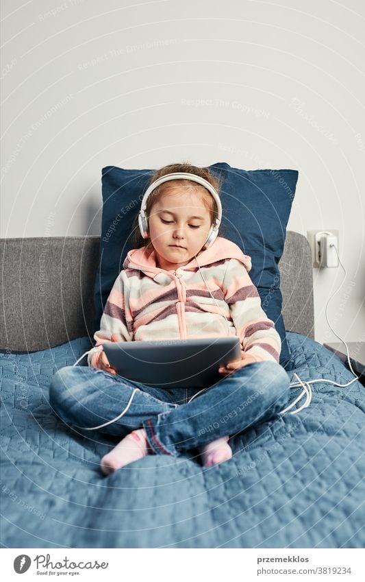 Kleines Mädchen im Vorschulalter lernt online Rätsel lösen und spielt zu Hause Lernspiele auf Tablet Bett Schlafzimmer Kaukasier Kind Kindheit Computer niedlich