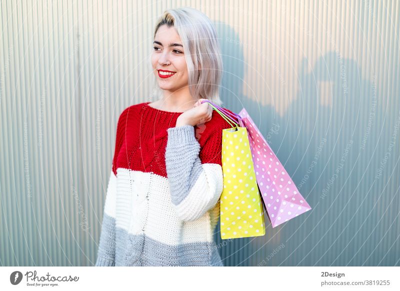 Porträt einer jungen, glücklich lächelnden Frau mit Einkaufstaschen Stehen 1 kaufen Tasche Käufer Fröhlichkeit schön Kauf Mädchen konsumgeil Lächeln Person