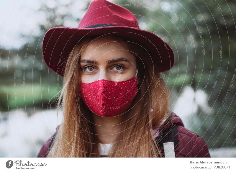 Schöne Frau mit rotem Hut und Gesichtsmaske in Nahaufnahme Erwachsener attraktiv schön Schönheit Kaukasier abschließen kalt Coronavirus covid-19 niedlich Mode