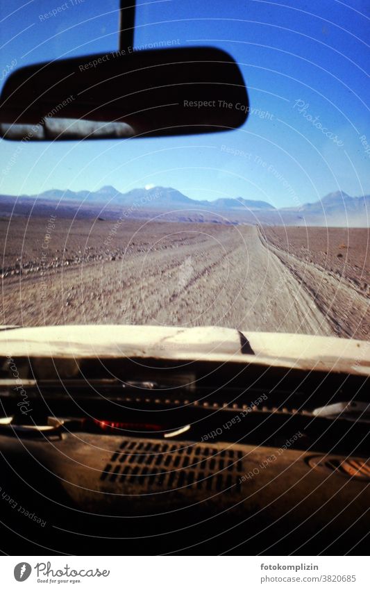 Cockpit eines alten Autos mit Blick nach vorne auf eine Wüstenpiste reisen Autospiegel Piste wüst Menschenleer Chile Wüstenberge Ferne Landschaft Nostalgie