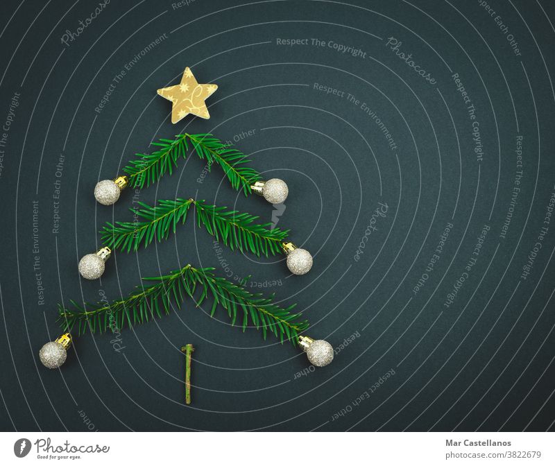 Weihnachtsbaum aus Kiefernzweigen auf schwarzem Hintergrund. Dekoration & Verzierung Weihnachten Ende des Jahres Baum Niederlassungen Stern Bälle