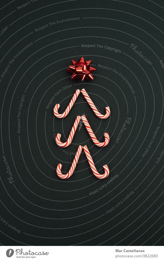Weihnachtsbaum aus Zuckerstangen auf schwarzem Hintergrund. Weihnachtskonzept. Dekoration & Verzierung Weihnachten Silvester u. Neujahr Stern
