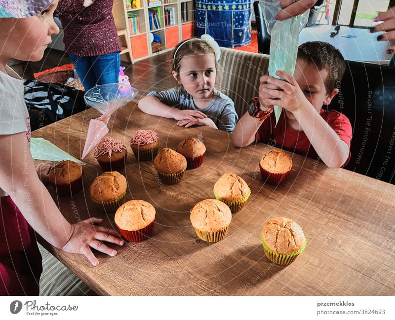 Kinder backen Muffins, bereiten Zutaten vor, dekorieren Kekse Cupcake dekorierend vorbereitend Essen zubereiten Familie heimisch Zusammensein Kindheit Glück