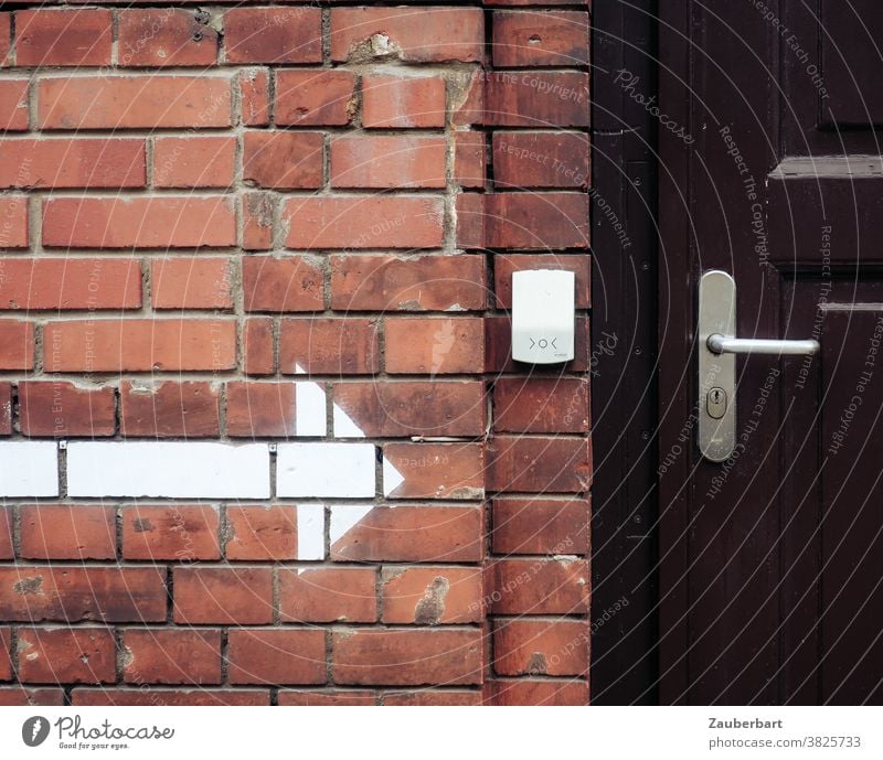 Ziegelwand, weißer Pfeil, Klingel und Holztür zeigen Wand Klinker ziegelrot Tür Türklinke Eingang Hinweis braun verschlossen Wegweiser Da lang Schloss