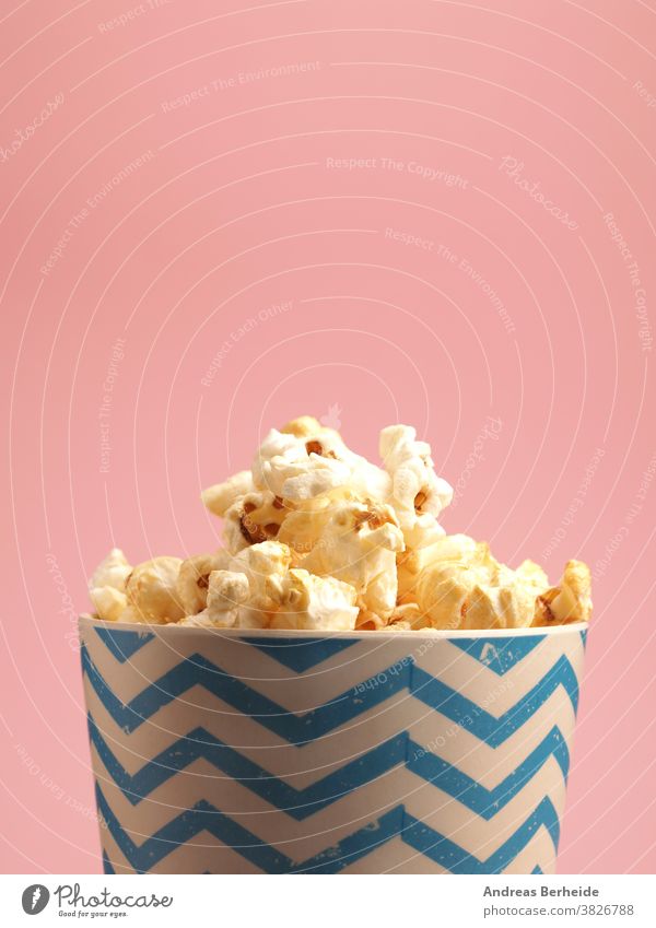 Frisches Popcorn auf rosa Hintergrund Amuse-Gueule Kasten Eimer Kino klassisch Nahaufnahme Farbe farbenfroh Container Textfreiraum Mais knackig Tasse lecker