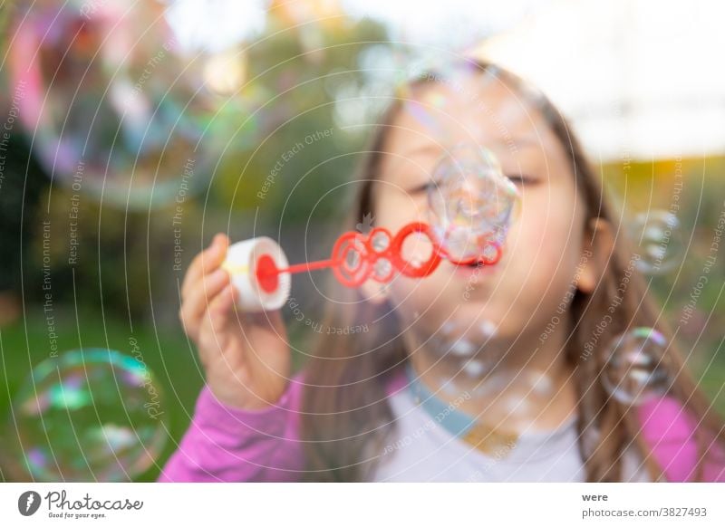 Ein kleines Mädchen macht Seifenblasen im Garten Blasen Kaukasier Kind Kindheit fliegend Fliegen. platzen zerbrechlich Spaß menschlich wenig Spielen s Seife